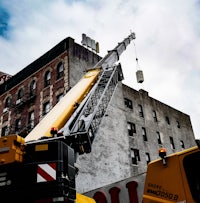 a crane is lifting a large container off of a building